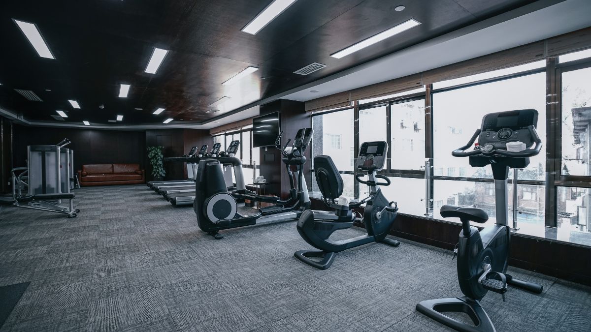 Moderné fitness centrum s rôznymi cvičebnými strojmi a pohodlným sedením.