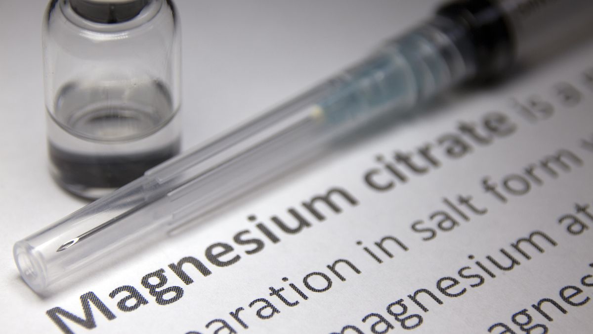 Syringe and vial next to a paper discussing magnesium citrate benefits.