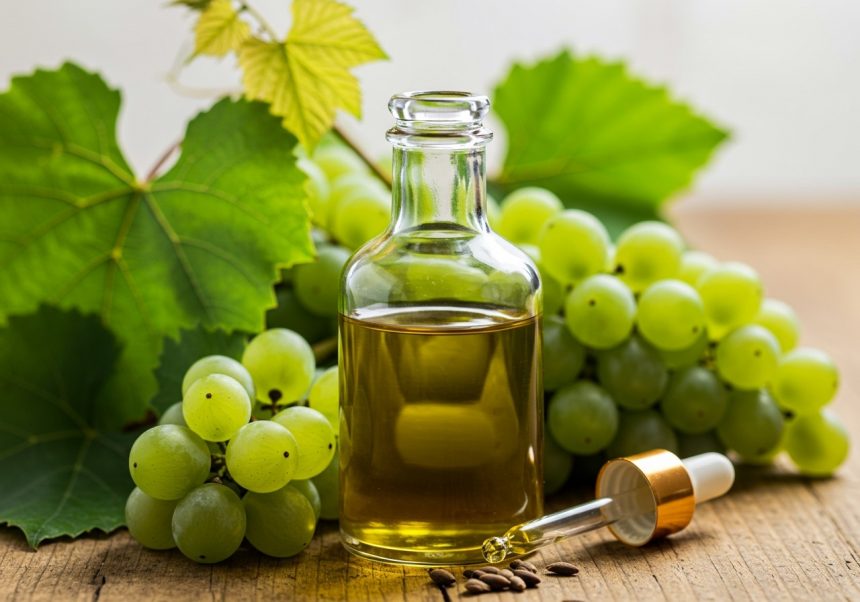 Fľaša za studena lisovaného oleja z hroznových jadier s hroznami a listami.