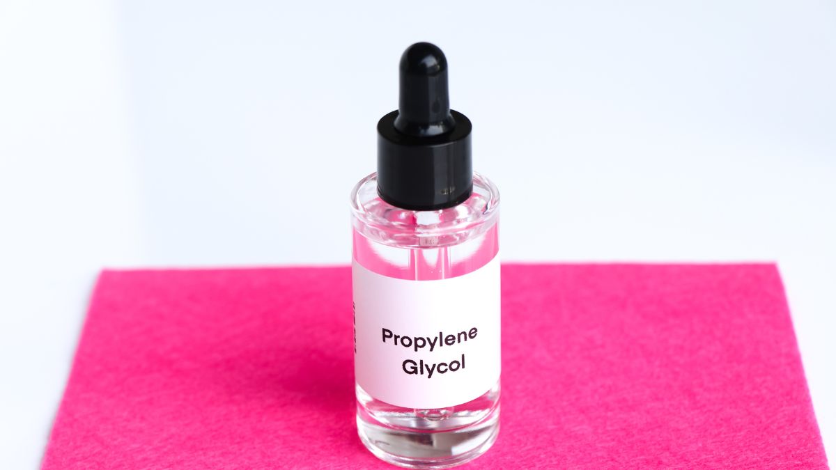 Fľaša s propylénglykolom na ružovom pozadí.