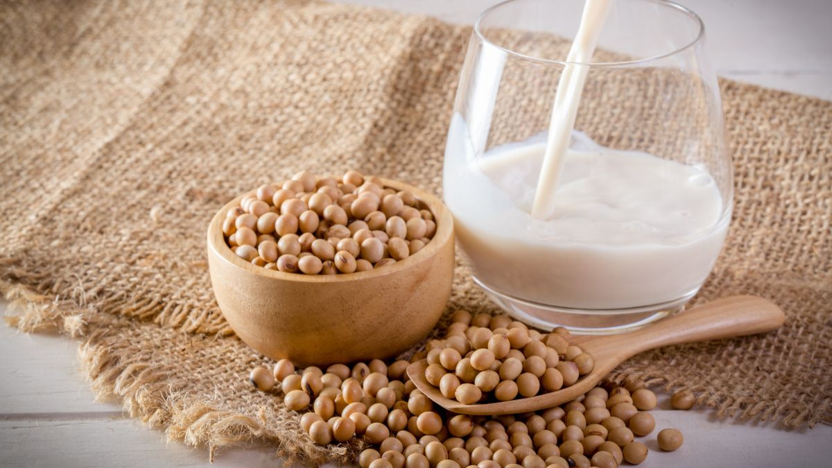 Miska sojových bôbov a pohár sójového mlieka na jute.