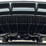 Detail tepelného krytu výfuku na automobile zospodu.