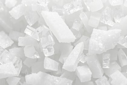 Chlorid hlinitý v kryštalickej forme na bielom pozadí