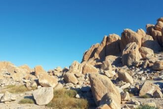 Prírodný krajinný pohľad na strmé skaly a kamene riolitu pod modrou oblohou.