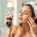 Žena nanášajúca kyselinu listovú na pleť v kúpeľni.