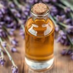 Fľaša domáceho levanduľového sirupu na drevenom stole s levanduľou