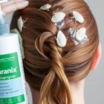 A bottle of Paranix shampoo being applied to hair infested with lice.